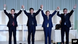 Former Foreign Minister Fumio Kishida, left, Japan's Prime Minister Shinzo Abe, Chief Cabinet Secretary Yoshihide Suga and former Defense Minister Shigeru Ishiba celebrate after Suga was elected as new head of Japan's LDP, Sept. 14, 2020, in Tokyo. 