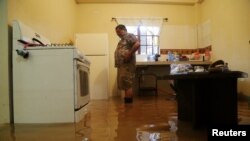 A resident stands in his home, flooded by a rain storm caused by Tropical Storm Karen, in Barataria, Trinidad and Tobago, Sept. 22, 2019.