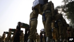 Pakistan soldiers carry the coffins of troops killed during an accidental NATO strike at a funeral in Peshawar, Pakistan, Nov. 27, 2011.