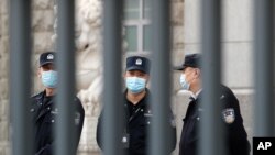 Policemen wearing face masks are seen at No. 2 Intermediate People's Court in Beijing, China, March 22, 2021.