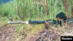 Un integrante del Ejército de Liberación Nacional (ELN) prueba su arma durante un ejercicio de entrenamiento cerca de las montañas de la ciudad de Tibú. Foto de archivo.