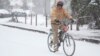Jesse Thompson anda en bicicleta en la nieve, el 10 de enero de 2025, en Nashville, Tennessee.
