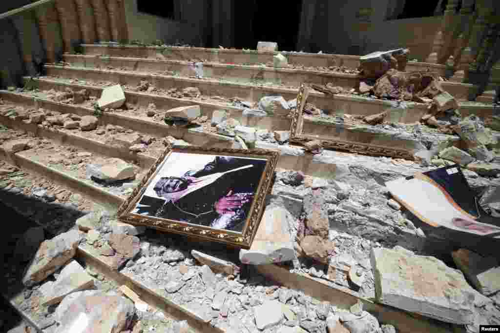 A picture of Saudi Arabia's King Salman bin Abdulaziz lies amidst the debris at the damaged headquarters of the Saudi Cultural Center. The damage to the building was caused by an April 20 airstrike that also hit a nearby army weapons depot, in Sana'a, Yemen, April 21, 2015.