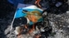FILE - Protesters burn an illustration of U.S. President Donald Trump being hit with shoes, in the West Bank city of Ramallah, Aug. 24, 2017.