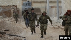 FILE - A rebel fighter runs with a weapon on the outskirts of the northern Syrian town of al-Bab, Syria, Jan. 26, 2017. 