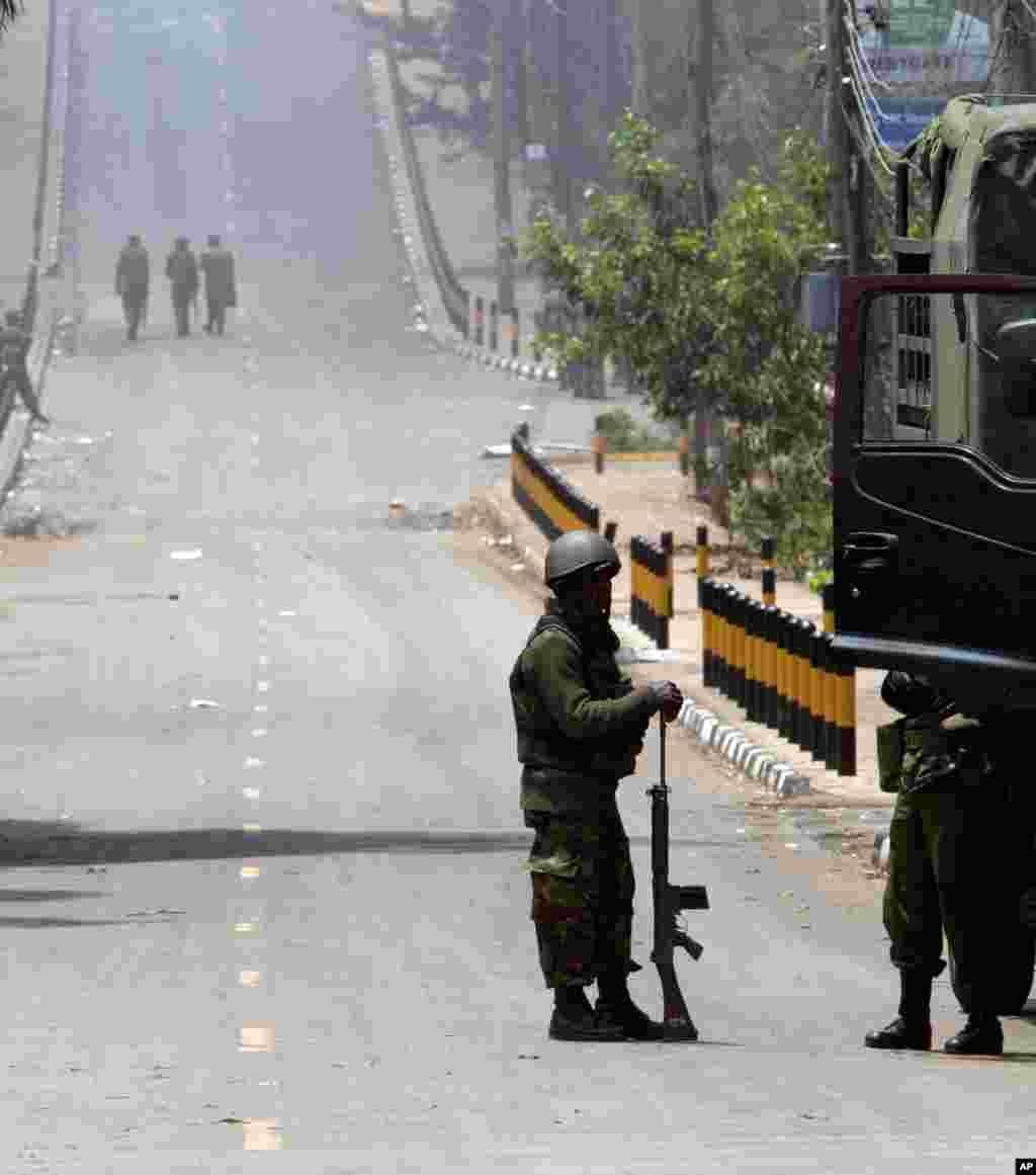 A Kenya Defense Forces soldier stands resting with his gun while others patrol on the empty road near the Westgate Mall in Nairobi, Sept. 25, 2013. 