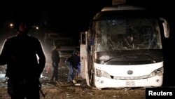 Police officers inspect the scene of a bus blast in Giza, Egypt, Dec. 28, 2018.