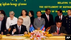 FILE - Australian Immigration Minister Scott Morrison signs a document together with Cambodian Interior Minister Sar Kheng on a deal for the resettlement of refugees, at the Interior Ministry in Phnom Penh, Sept. 26, 2014. 