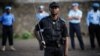 United Nations peacekeepers stand in the background as a Congolese national police officer holds a sword and stands with other officers during a gathering in Goma, in the Democratic Republic of Congo, December 2, 2012. 