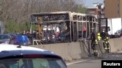 Rongsokan bus yang dibakar oleh sopirnya di sebuah jalan dekat Milan, Italia, Rabu (20/3). 