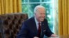 El presidente Joe Biden sonríe a los periodistas tras firmar dos acciones ejecutivas en la Casa Blanca, el 28 de enero de 2021.