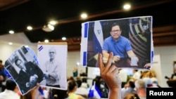 CIDH solicita a Corte Interamericana, ordene al estado nicaragüense respetar la integridad de líderes opositores detenidos, para los que existen medidas cautelares que han sido violadas. Persona levanta foto de periodista Miguel Mora (Foto archivo)