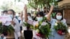 Perempuan membawa pot dengan bunga untuk mengambil bagian dalam protes terhadap kudeta militer di Yangon, Myanmar 13 April 2021. (Foto: Reuters)