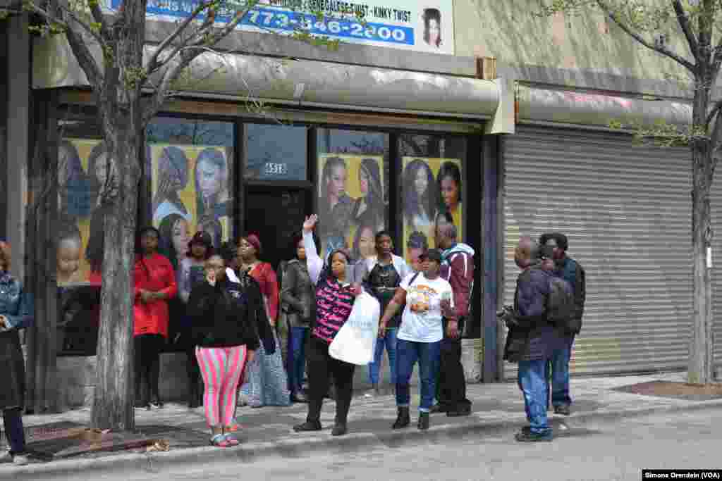 Women step out of a neighborhood hair salon to cheer on participants of a prayer walk marching for peace in their neighborhood, Englewood, on Chicago's South Side, April 14,2017. The area is regularly hit with gun violence.