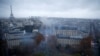 Para pengunjuk rasa mengenakan rompi kuning, simbol protes para pengendara Perancis terhadap kenaikan pajak solar, berdemonstrasi di Place de l'Etoile, Paris dengan latar belakang menara Eiffel, Perancis, 1 Desember 2018. (Foto: dok).