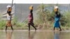 Des déplacés transportent de la nourriture de secours dans les eaux de crue à Gumuruk, dans l'État de Boma, dans la région du Grand Nil Supérieur au Soudan du Sud, (Reuters)