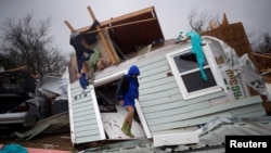 Barbara Koster stands on her front door as she surveys her property which was left devastated by Hurricane Harvey in Rockport, Texas, U.S. August 26, 2017.