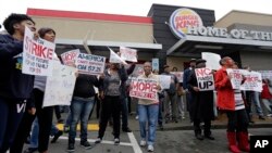 Para pekerja berunjuk rasa di luar restoran Burger King di Charlotte, North Carolina, Kamis (5/12), menuntut kenaikan upah. (AP/Chuck Burton)