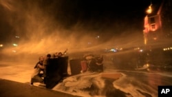 Lebanese anti-government protesters are sprayed by water cannons during a protest in Beirut against the ongoing trash crisis and government corruption, Oct. 8, 2015.