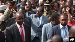 Zimbabwean President Robert Mugabe, centre, gestures after addressing members of the Zimbabwe National Liberation War Veterans Association, at the party headquarters, in Harare on July, 27, 2016.