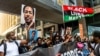 People raise their fists and hold signs and a banner as they march during an event in remembrance of George Floyd in Minneapolis, Minnesota, on May 23, 2021. 