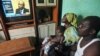 Adama Fofana, who says two of his brothers were killed in post-election violence and their bodies dumped in a mass grave, watches the televised trial of former Ivorian President Laurent Gbagbo, Feb. 19, 2013. 