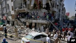 Pakistan's troops and rescue workers look for survivors in the rubble following the explosion, in Karachi, Pakistan, Oct. 21, 2020.