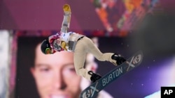 Peselancar dari AS, Shaun White, beraksi di dekat gambar dirinya dalam nomor "snowboard halfpipe" pria yang dipertandingkan dalam Olimpiade Musim DIngin di Rosa Khutor, Sochi, Rusia (11/2).