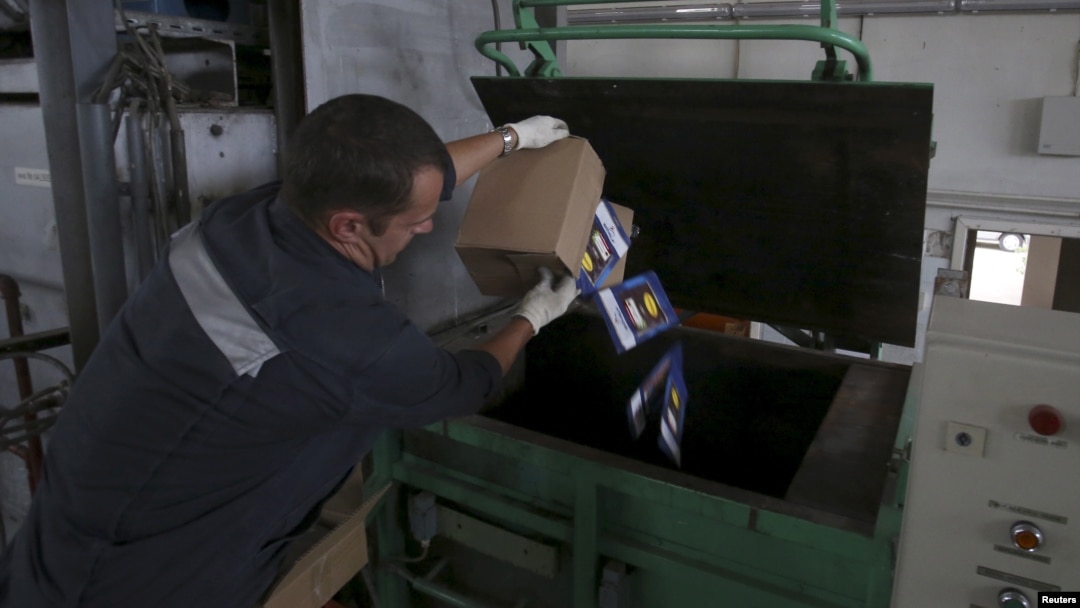 An employee throws sliced and packed meat into a furnace during the destruction of illegally imported food at a customs house at Pulkovo Airport in St. Petersburg, Russia, Aug. 6, 2015.