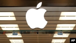 FILE - The Apple logo is seen above a store location entrance, in Dallas, Texas, Sept. 19, 2013.