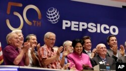 FILE - PepsiCo Chairwoman and CEO Indra K. Nooyi, center, is applauded as she rings the New York Stock Exchange opening bell to celebrate the 50th anniversary of the merger of Frito-Lay and Pepsi-Cola, June 8, 2015.