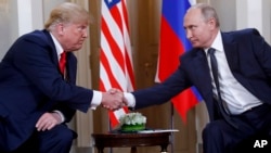 FILE - U.S. President Donald Trump, left, and Russian President Vladimir Putin shake hands at the beginning of a meeting at the Presidential Palace in Helsinki, Finland, July 16, 2018.