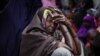 FILE -In this photo released by the AU-UN Information Support Team Aug. 31, 2013, a woman and children wait to see a doctor at a free medical clinic in the southern Somali port city of Kismayo. The clinic treats a variety of illnesses, including malaria. 