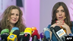 Two members of Russian punk group Pussy Riot, Nadezhda Tolokonnikova (R) and Maria Alyokhina (L), answer journalists' questions during their news conference in Moscow on December 27, 2013. 
