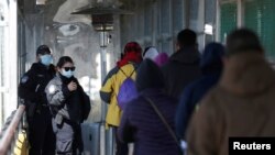 Un grupo de personas camina hacia Brownsville, Texas, EE.UU., en el puente fronterizo internacional Matamoros-Brownsville, visto desde Matamoros, México, el 19 de febrero de 2021.