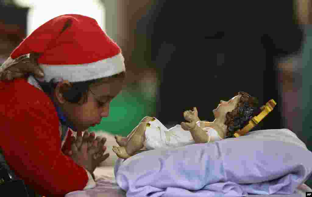 A girl prays at Saint Mary's Garrison Church in Jammu, India, Dec. 25, 2016. Though the Hindus and Muslims comprise majority of the population in India, Christmas is a national holiday celebrated with much fanfare.