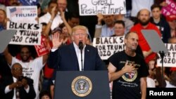 A supporter invited onstage by U.S. President Donald Trump puts his hand to his chest during a "Make America Great Again" rally at Orlando Melbourne International Airport in Melbourne, Florida, Feb. 18, 2017.