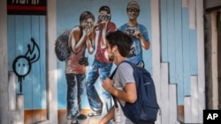 Un hombre usa una máscara facial mientras camina por una calle en Tel Aviv, Israel, el domingo 15 de marzo de 2020. Israel ha impuesto una serie de restricciones severas para frenar la propagación del nuevo coronavirus.