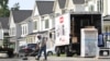 Un trabajador barre la calle frente a una hilera de casas nuevas en Fairfax, Virginia, el 22 de agosto de 2023, los economistas prestan gran atención a este sector como indicador clave del comportamiento de la economía.