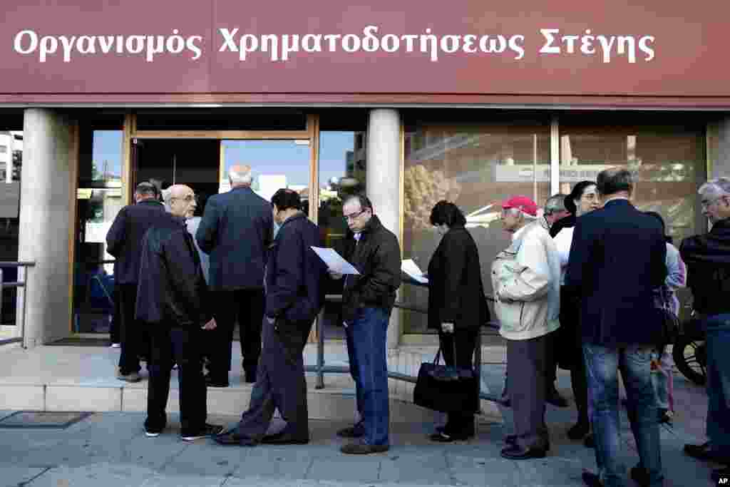 People line up outside a branch of Cyprus' Housing Finance Corporation, a state-run bank that mainly helps low and middle income people, in capital Nicosia, March 29, 2013.