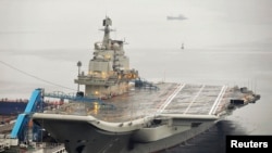 FILE - China's first aircraft carrier, which was renovated from an old aircraft carrier that China bought from Ukraine in 1998, is seen docked at Dalian Port, in Dalian, Liaoning province September 22, 2012. 
