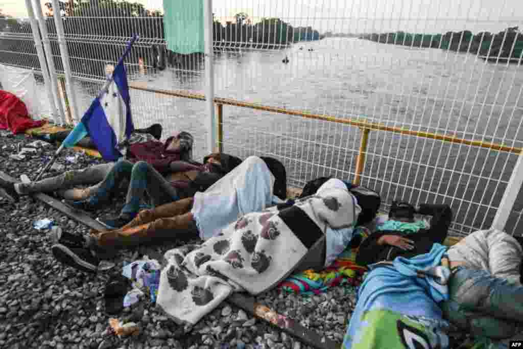 Migrantes descansan en la frontera entre Guatemala y México, en Tecún Umán, Guatemala, el 21 de octubre del 2018.