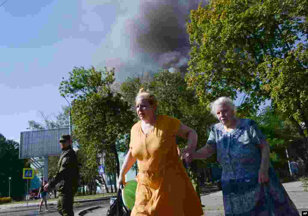Women rush across the street after shelling in the town of Donetsk, eastern Ukraine, Aug. 27, 2014. 