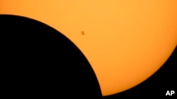 En esta imagen difundida por la NASA se ve la silueta de la Estación Espacial Internacional con el Sol de fondo durante un eclipse solar, el 21 de agosto de 2017, en una fotografía captada desde el lago Ross, en el Parque Nacional Northern Cascades, en el estado de Washington.