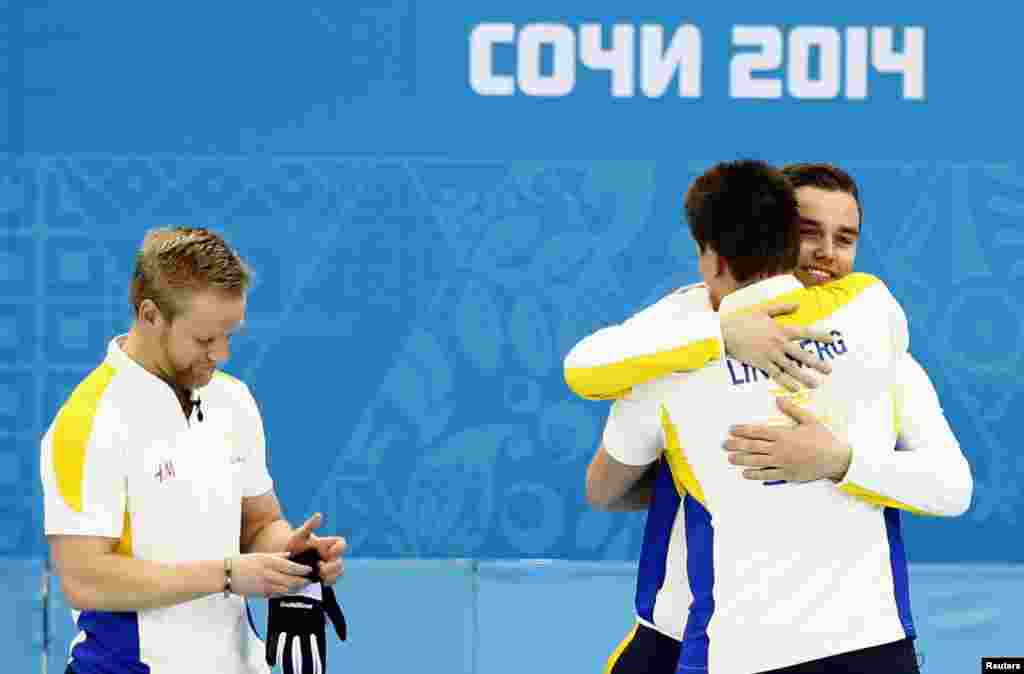 Sweden's second Fredrik Lindberg is congratulated as skip Niklas Edin stands after winning their men's bronze medal curling game against China at the Ice Cube Curling Center, Feb. 21, 2014.