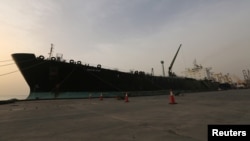FILE - A cargo ship unloads a shipment of fuel at the Hodeida port, Yemen, May 27, 2018. 