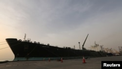 FILE - A cargo ship unloads a shipment of fuel at the Hodeida port, Yemen, May 27, 2018. 