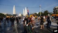 Para demonstran anti-pemerintah menyapu jalan di depan Monumen Demokrasi di Bangkok, Thailand (4/12). (AP/Vincent Thian)