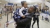 Abdisellam Hassen Ahmed, a Somali refugee who had been stuck in limbo after President Donald Trump temporarily banned refugee entries, holds his 2-year-old daughter, Taslim, after meeting her for the first time upon arriving at Salt Lake International Airport.