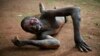 Kevin, a man accused of being a thief by civil servants at the Work Inspection office, lies in pain after being attacked by a man with a machete and sticks in plain view of others in Bangui, Central African Republic, April 18, 2014.